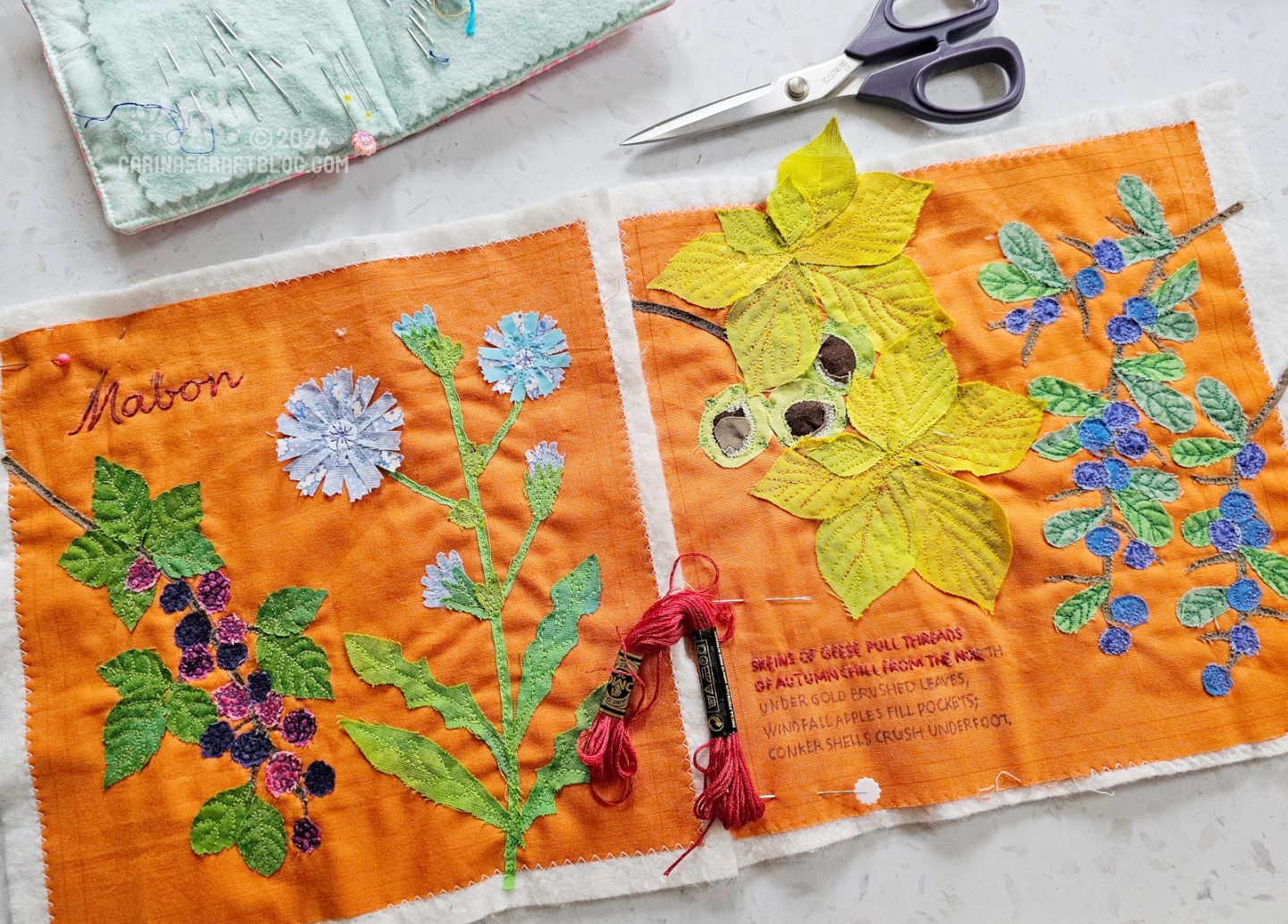 Overhead view of two orange fabric squares with different plant illustrations appliquéd on.